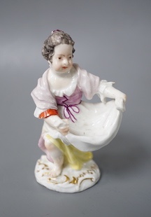 An 18th century Meissen figure of a girl holding her apron to make a basket shape kneeling on the mound scroll moulded base, small crossed swords in blue on the backside of the base. 9.5cm